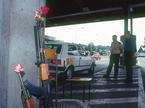 Krvavi Potok, 25. junij 1991 - puške znamke kalašnikov z rožami v ceveh, so naslonjene na zid na mejnem prehodu, kjer policisti in vojaki preverjajo potne liste med 10-dnevno vojno