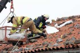 Gasilci obtežujejo streho med močno burjo v Ajdovščini