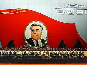 Delegati severnokorejske komunistične partije zasedajo pod sliko ustanovitelja države Kim Il Sunga.