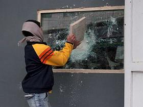 Palestinec razbija mednarodno pisarno v Hebronu.