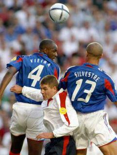 Steven Gerrard v primežu francoskih branilcev.
