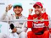 Takole sta se po zadnji dirki v Maleziji na odru za zmagovalce zabavala Lewis Hamilton in Sebastian Vettel. Nemec je bil izrazito boljše volje. Foto: EPA