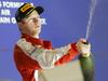 Kimi Räikkönen je takole s šampanjcem 'ohladil' tekmeca in svoje moštvo pod zmagovalnim odrom, preostanek je Finec popil. Foto: EPA