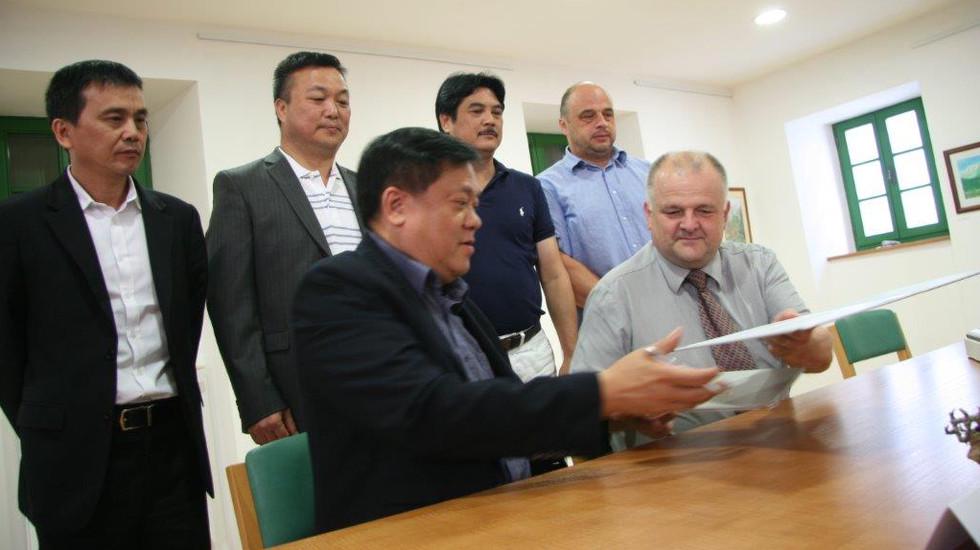 Predsednik Gospodarske zbornice iz Hong Konga George So in župan občine Kobarid Robert Kavčič podpisujeta pismo o nameri. V ozadju, skrajno desno, je pobudnik srečanja Marko Miklavič. Foto: Mariša Bizjak.