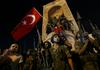 V bližini trga Taksim, kjer naj bi se spopadli vojska in policija, se zbirajo ljudje s turškimi zastavami. Foto: Reuters
