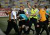 Varnostniki in predstavniki NK Maribor so morali takole pred letečimi predmeti s tribun zaščititi glavnega sodnika Nejca Kajtazovića ob odhodu iz Ljudskega vrta. Foto: Miloš Vujinović/BoBo