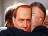 Podpornika Gibanja petih zvezd z maskama nekdanjih premierjev Silvia Berlusconija in Mattea Renzija. Foto: Reuters
