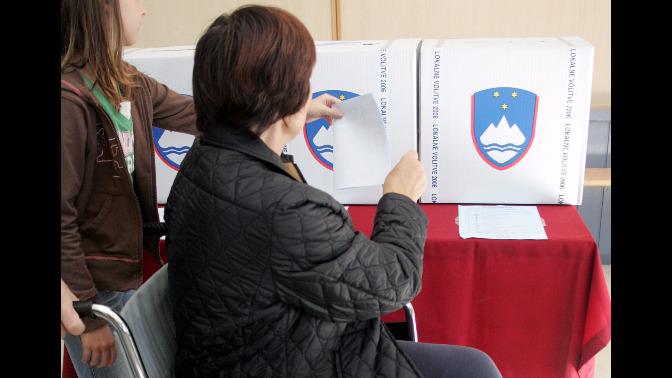 Volivka na invalidskem vozičku oddaja glasovnico.