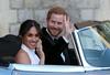 Meghan Markle in princ Harry sta takole pomahala zbranim ob odhodu na poročni sprejem, ki ga je gostil Harryjev oče, princ Charles. Foto: Reuters