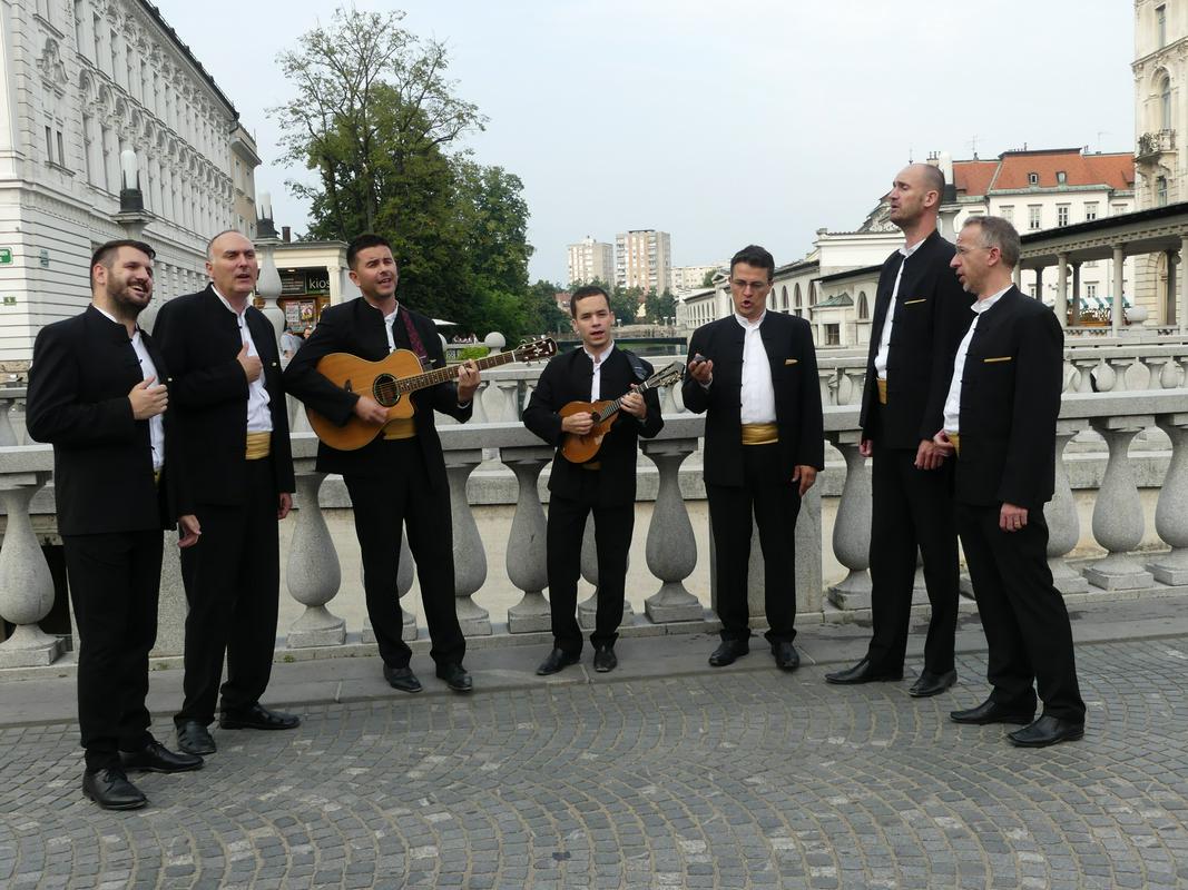 Klapa Kampanel je letošnje poletje že večkrat nastopila v Sloveniji. Tukaj jih vidimo, kako so na Tromostovju prepevali a cappella pesem Moja, ki jo v originalu izvajajo Modrijani. Mimoidoči so se ustavljali in z veseljem prisluhnili mini dalmatinskemu koncertu. Foto: MMC RTV SLO/Tanja Mojzer