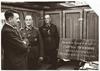 Adolf Hitler si ogleduje spominsko ploščo, posvečeno Gavrilu Principu, atentatorju na avstro-ogrskega prestolonaslednika Franca Ferdinanda, kar je bil povod za izbruh prve svetovne vojne. Ob 52. rojstnem dnevu 20. aprila 1941 so mu jo kot darilo poslale nemške enote, ki so ravnokar zasedle Kraljevino Jugoslavijo. Fotografijo je v poveljniškem vlaku