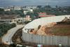 Izrael vzdolž meje z Libanonom gradi devet metrov visok zid. Na posnetku pogled na libanonsko vas Kfar Kila. Foto: Reuters