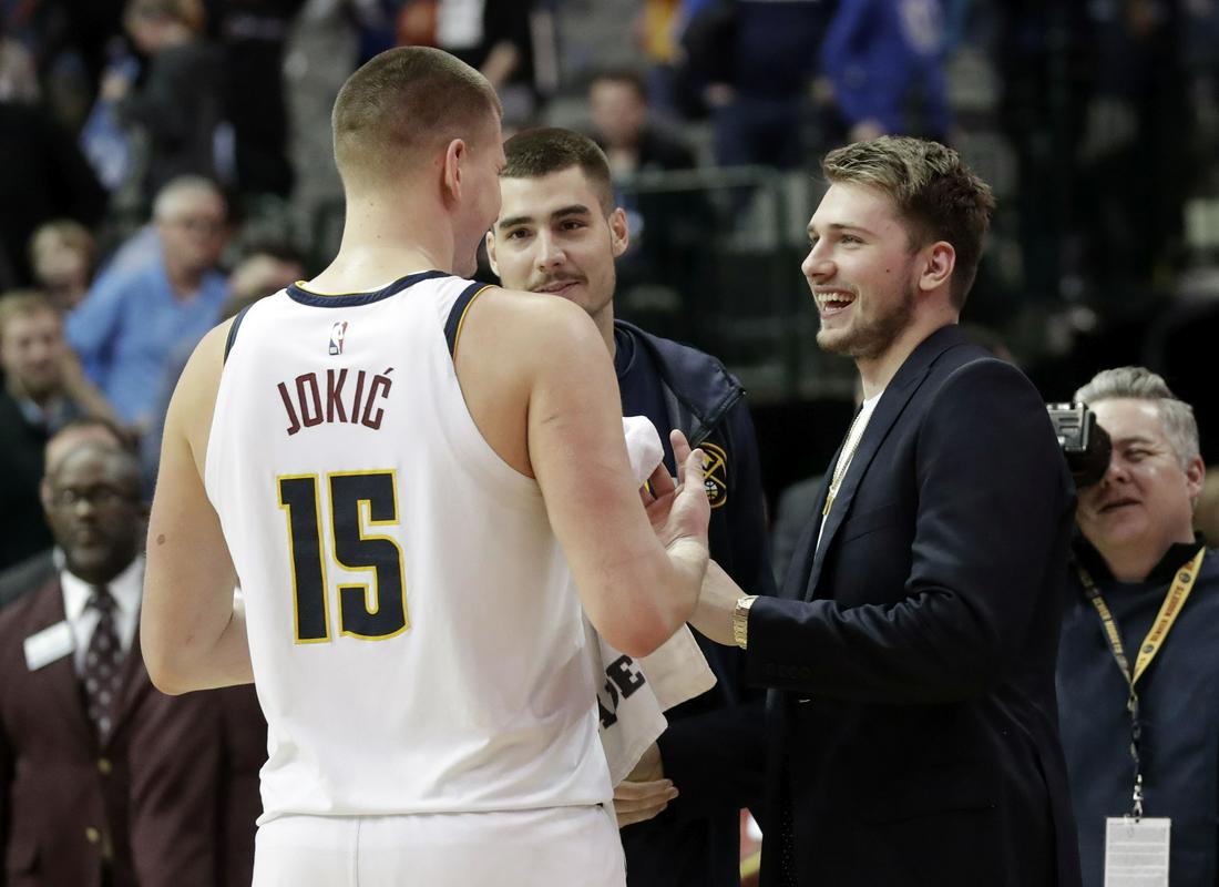 Nikola Jokić je pozdravil Dončića, ki je tekmo spremljal v obleki. Oba zvezdnika sta se zelo zabavala že prejšnji teden na spretnostnem poligonu v Charlottu. Foto: AP Nikola Jokić je pozdravil Dončića, ki je tekmo spremljal v obleki. Oba zvezdnika sta se zelo zabavala že prejšnji teden na spretnostnem poligonu v Charlottu. Foto: AP