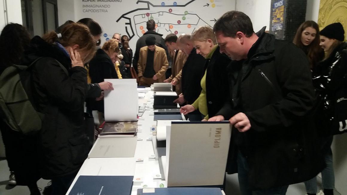 Prvi obiskovalci so si z navdušenjem ogledali razstavljene diplome. Foto: Radio Koper