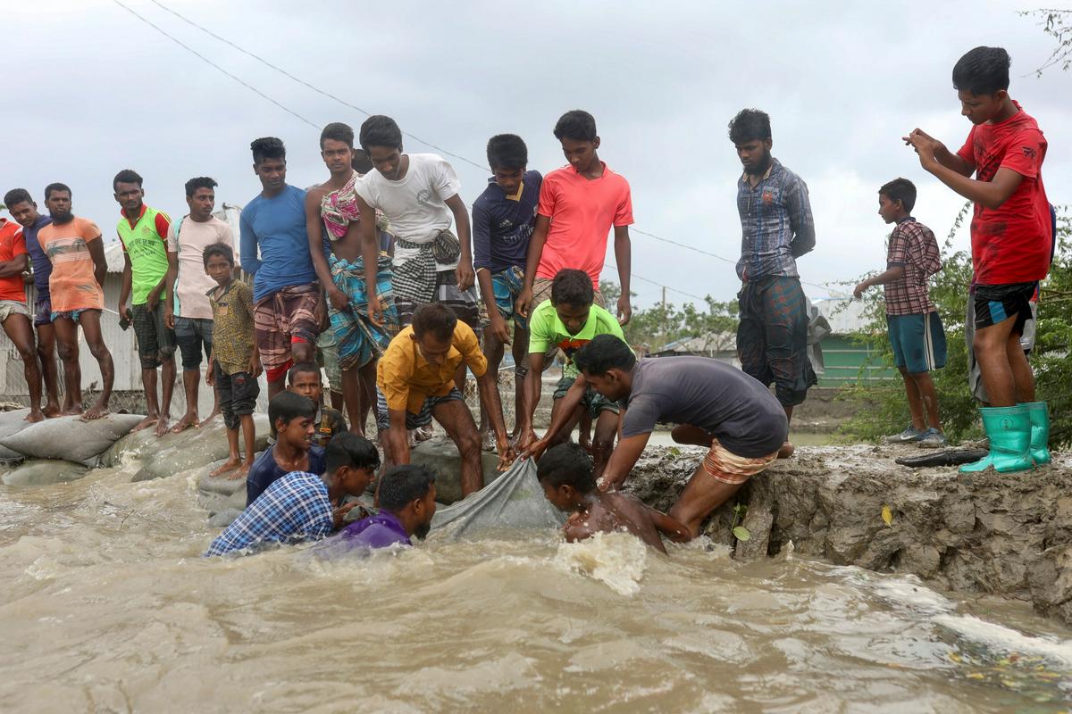 Prebivalci Gabure v Bangladešu utrjujejo nasip pred prihodom ciklona. Foto: Reuters Prebivalci Gabure v Bangladešu utrjujejo nasip pred prihodom ciklona. Foto: Reuters