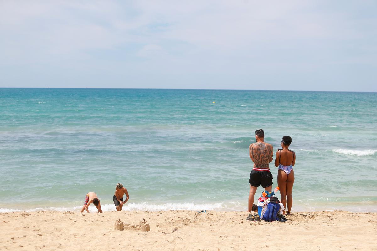 Španija skuša rešiti poletno turistično sezono. Nekaj ljudi na peščeni blaži ob morju. Foto: Reuters