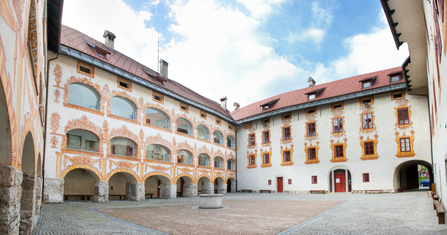 Notranje dvorišče gradu Gewerkenegg v Idriji. Mogočno poslopje z vseh strani obkroža tlakovano dvorišče. Pročelja zidov so bogato okrašena. Foto: arhiv Mestnega muzeja Idrija Notranje dvorišče gradu Gewerkenegg v Idriji. Mogočno poslopje z vseh strani obkroža tlakovano dvorišče. Pročelja zidov so bogato okrašena. Foto: arhiv Mestnega muzeja Idrija