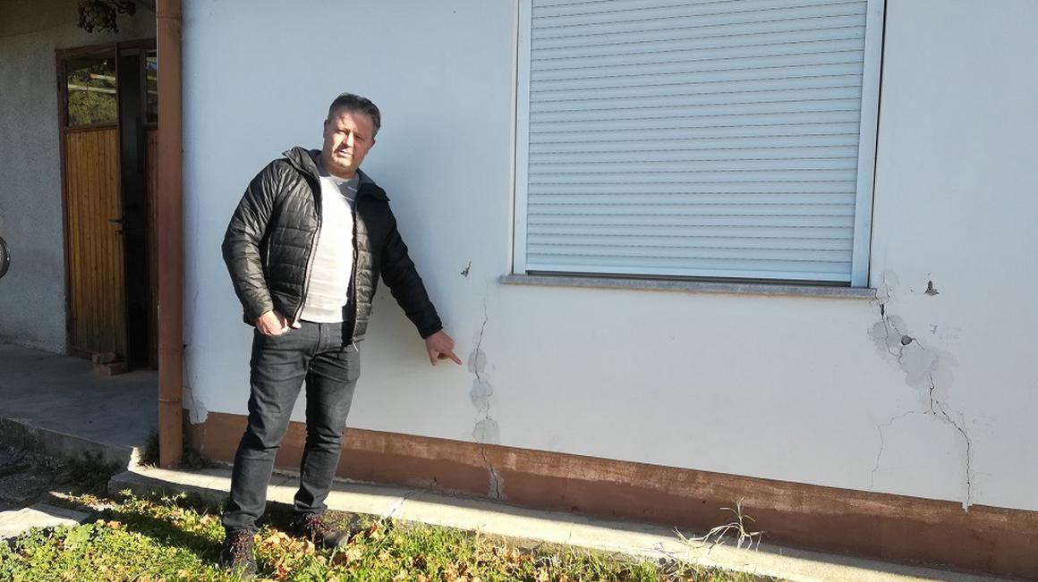 Predsednik KS Šmihel Marko Tribušon kaže razpoke na hiši. Foto: Radio Koper/Karin Zorn Čebokli